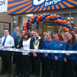 Staff pose outside B&M's latest store at the opening ceremony in Bicester.