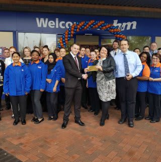 Clare Thomas Walker gratefully receiving £250 worth of B&M vouchers on behalf of the Sue Ryder charity.