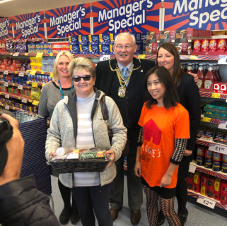 The new store's very first customer poses with her free hamper. She is stood with Tu Edwards from local charity the Maggies Centre who received a donation of £250 worth of B&M vouchers.