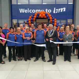 Mayor of Belper Gary Spendlove, supported by Sue Ryder charity, cuts the ribbon at B&M Belper store's re-opening, following a 9 month redevelopment.