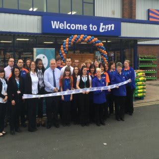 Minworth store manager Gary Rogers is joined by representatives from John Taylor Hospice who cut the ribbon on a landmark day for B&M