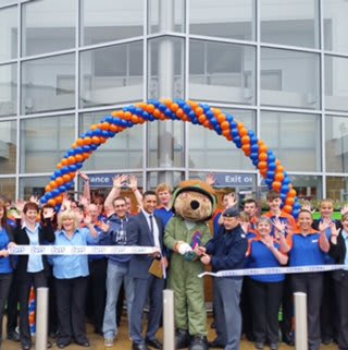 Elgin store being opened by the Help The Heroes Foundation representative FS Tony Walker with Cpl James Magee as their mascot bear who cut the ribbon.
