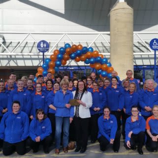 Store manager Emma Wilson presents Mrs Bowden from local charity League of Friends at Tonna Community Hospital with £250 of B&M vouchers.