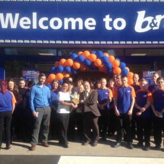 Radio Metro's Cash for Kids charity pose with staff as they receive £250 worth of B&M vouchers, as a thank you for taking part in the opening ceremony.