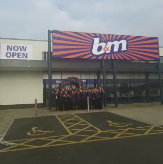 The store team at B&M's newest store in Breightmet pose in front of their wonderful new store, located on Bury Road.